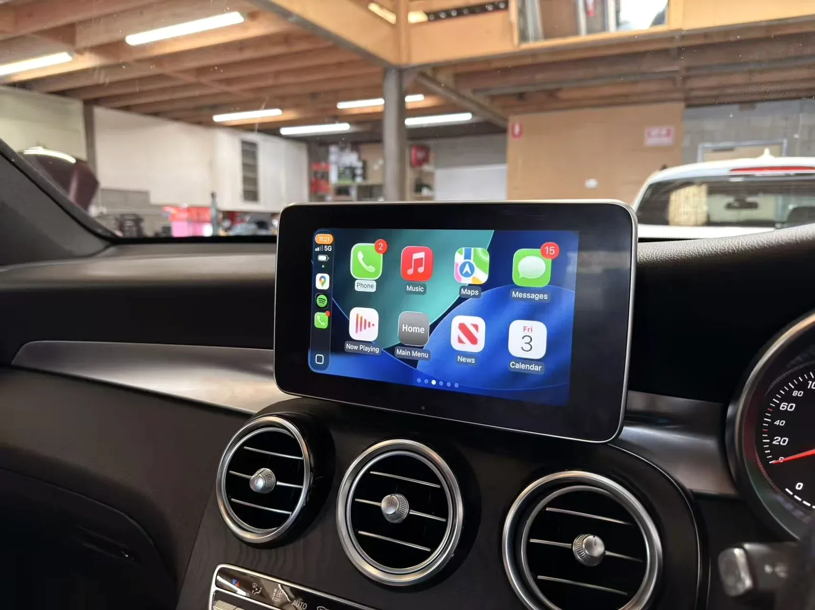 Wide dashboard view of a smartphone integration screen installed in a European vehicle at the workshop